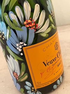 a close up of a bottle of wine with flowers painted on the top and bottom