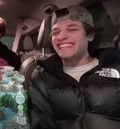 two people sitting in the back seat of a car with water bottles on their laps