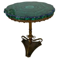 a green marble topped table with an ornate metal base