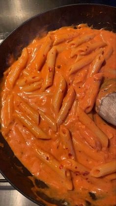 a pan filled with pasta and sauce on top of a stove