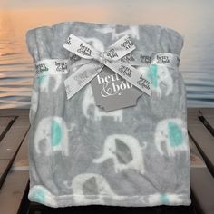 an elephant print blanket sitting on top of a wooden dock