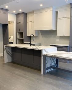 an empty kitchen with white cabinets and marble counter tops, is shown in this image