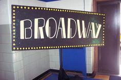 a broadway sign in front of a door