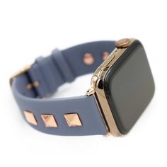 an apple watch with gold studs on it's face and blue leather band