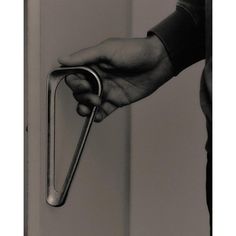 a person holding onto a door handle with one hand and the other hand on it