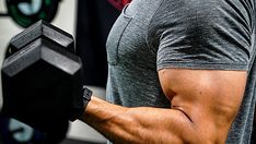 a man holding a black dumbbell in his right arm