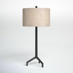 a lamp that is sitting on top of a table next to a white wall and floor