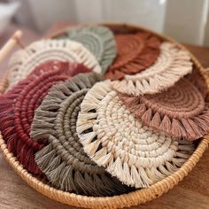 a woven basket filled with lots of different colored rugs on top of a wooden table