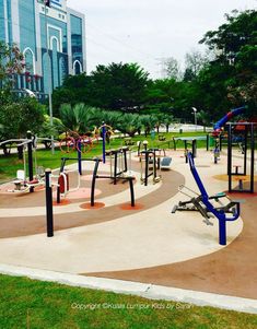 an empty playground in the middle of a park with lots of swings and climbing equipment