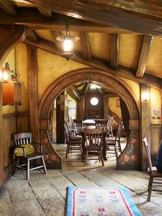 a dining room with an archway leading to the kitchen and sitting area is pictured in this image