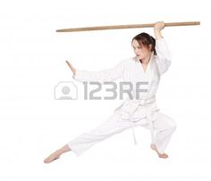 a woman is doing karate with a stick