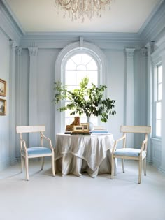 an image of a table with chairs and a vase on it in front of a window