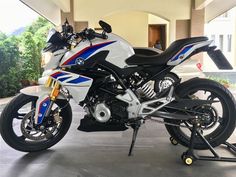 a white and blue motorcycle parked in a garage