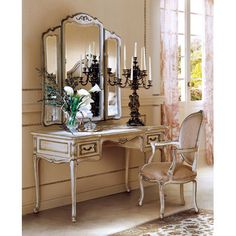 a white dressing table with a mirror and two chairs