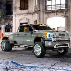 a silver truck parked in front of a building