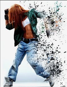 a woman with red hair and jeans is dancing in the air, splashing paint all over her body