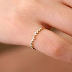 a woman's hand with a diamond ring on her left finger, showing the side view