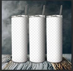 three white tumblers sitting next to each other on top of a wooden table in front of a gray background