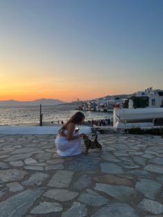 a woman sitting on the ground next to a dog