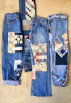 several pairs of jeans with patchwork on them are laying next to each other,