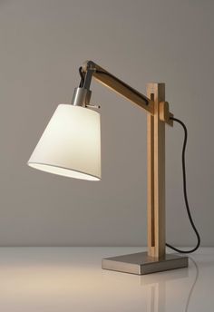 a desk lamp with a white shade on it's head and a black cord