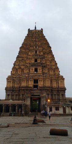 the entrance to an ancient temple with people walking around