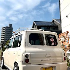 a small white van parked in front of a building