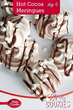 there are four cookies on the plate with chocolate drizzled on top and white frosting