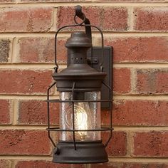 an old fashioned lantern on the side of a brick wall with a light bulb in it