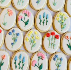 decorated cookies arranged in rows with flowers on them