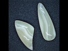 two pieces of white jade sitting on top of a black table next to each other