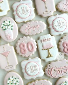 decorated cookies with pink and white frosting are arranged on a countertop for a celebration