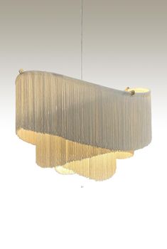 a chandelier hanging from the ceiling with two shades of beige and one light brown