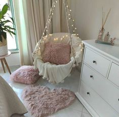 a bedroom with pink rugs and lights on the ceiling, white dresser and bed