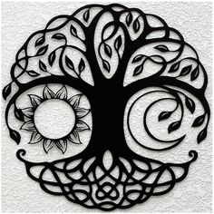 an intricate metal tree with the sun and moon in it's center, on a white wall