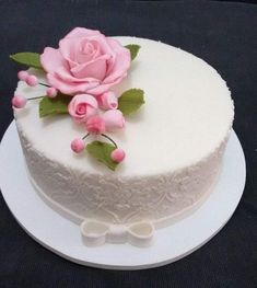 there is a white cake with pink flowers on it