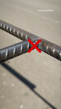 a close up of a metal fence with a red cross on it