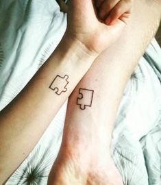 two people with matching tattoos on their arms, one has a piece of the puzzle