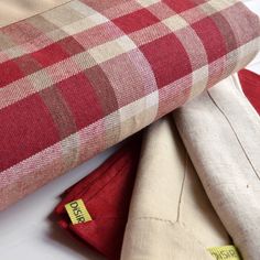 three pieces of fabric are laying on top of each other, one red and the other beige