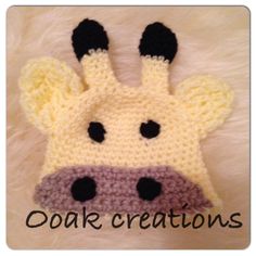 a crocheted giraffe hat with black eyes