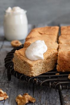 a piece of cake sitting on top of a black plate next to a glass of milk