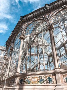 an ornate glass and metal building with blue sky in the background