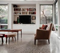 a living room filled with furniture and lots of windows