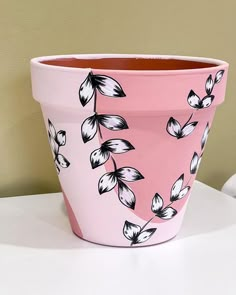 a pink flower pot sitting on top of a white table