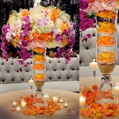 two tall vases filled with flowers and candles on top of a white table cloth