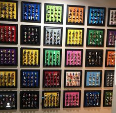 a wall that has many framed pictures on it with legos all over the wall