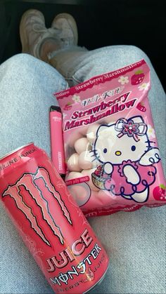 the hello kitty candy is sitting on someone's lap next to their pink drink