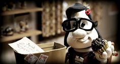 a stuffed animal with glasses holding a donut in front of a cardboard box filled with cards