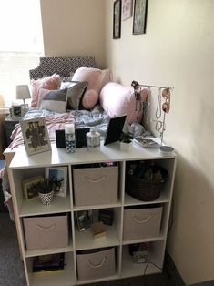 a bed room with a neatly made bed and several storage bins on the side