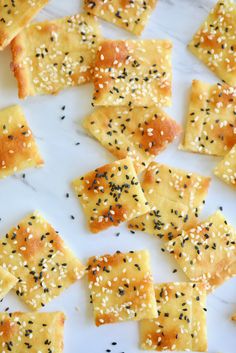 sesame seed crackers are arranged on a white plate with black sprinkles